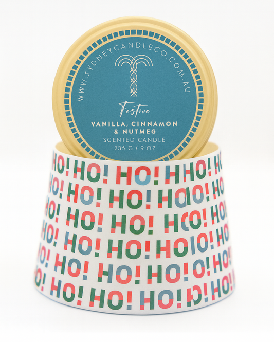 Scented candle with 'Ho Ho Ho' pattern and vanilla, cinnamon, nutmeg description