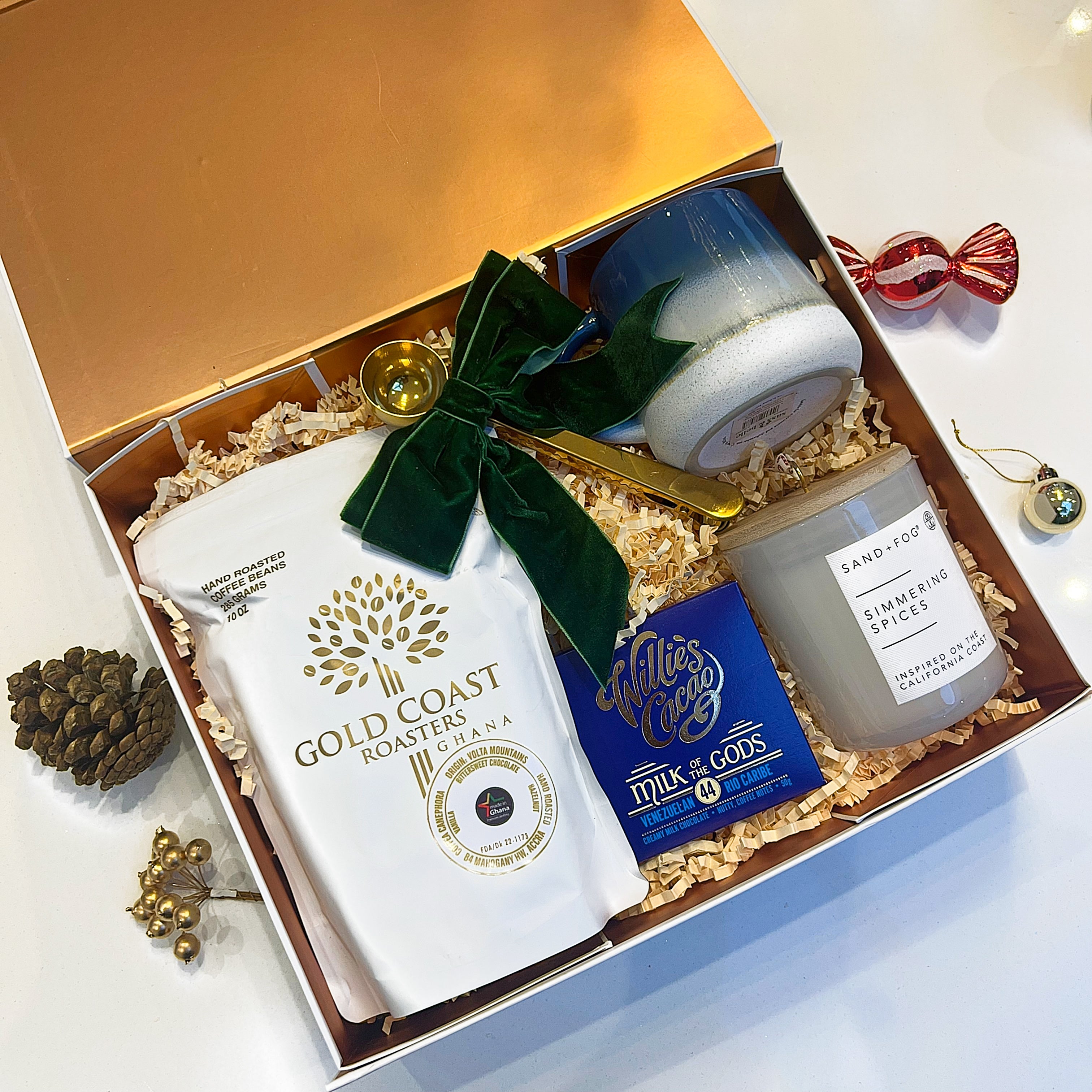 Gift box with Gold Coast Roasters coffee, candles, and a small bag on a white background